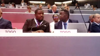 La conférence internationale se poursuit avec la présence de la mission diplomatique du Togo en Suisse représentée par M. Kanyi Géraud FOLIVI (à côté du Président National), Conseiller à ladite mission.
